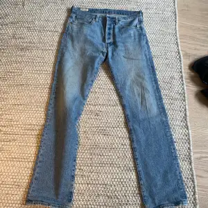 Ljusblå Levi’s 501 jeans. Använda men bra skick utöver två mindre hål, enkla att fixa dock. Därav priset Storlek: W 31, L 32 