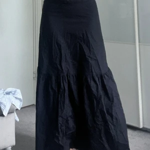 Svart långkjol - Svart långkjol från Lindex i strl S. Börjar ganska smal och breddar sedan ut lite i volang. Den har en dragkedja på baksidan🖤🖤
