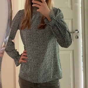 Grönvit blus - En grönvit blus som är långärmad och går upp lite i halsen