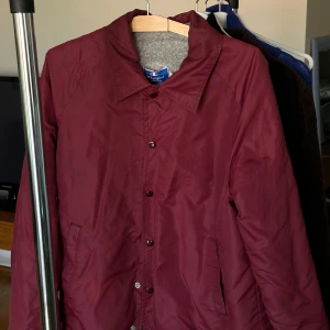 Vintage Champion jacka - Retro Champion vindjacka i vinrött.  Riktigt snygg jacka som är i mycket bra skick.  Bra under lite blåsigare väder. Jag är 175cm lång och den sitter som ni ser på bilden.