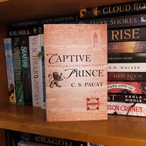 Bok 1 i serien 'Captive prince Triology' skriven av C.S. Pacat. Lite sliten men annars inga anmärkningar.   Kolla min profil för fler böcker! Allt ska bort!!