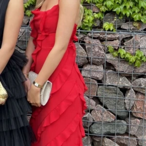 Röd balklänning  - Säljer min fina röda balklänning. Klänningen har en slits längst ner som du kan se på sista bilden. Går att justera hur tight du vill ha klänningen eftersom du knyter den i ryggen. Slutsåld. 