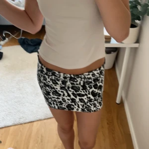Leopard kjol - Kjol i leopard mönster. Är ganska kort och passar strl 34. Jag har strl 36/38 så den är för liten. Funkar även som en tub topp. Finns ej varumärke på tröjan.