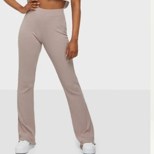 Utsvängda byxor - Byxor i mycket stretchigt material, tyvärr skadade vid fötterna men annars fina. Beige/rosa färg