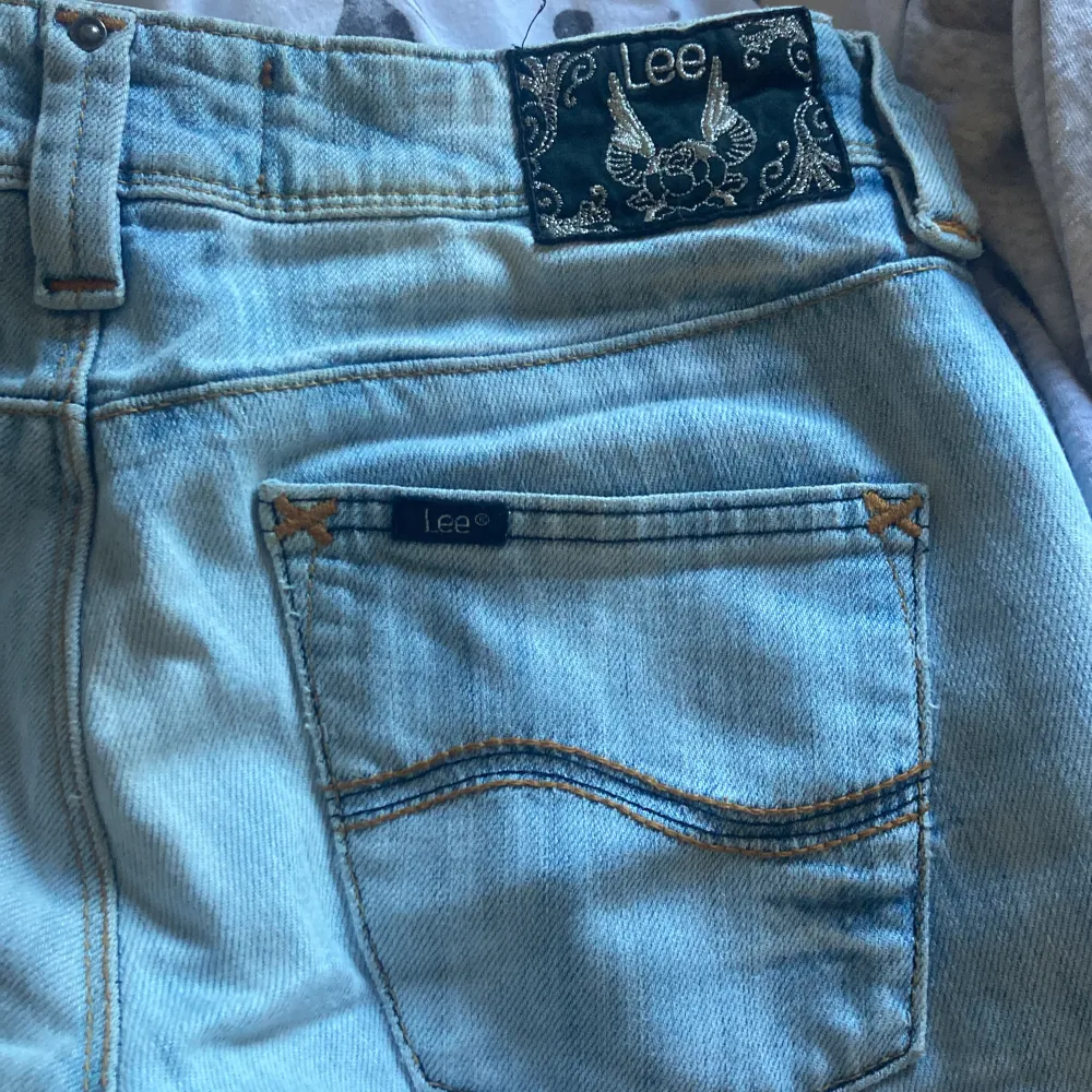 sjukt snygga lågmidjade, ljusblåa Lee jeans som kommer från tidigt 2000 tal med snygga svarta detaljer🙌🏼🙌🏼🙌🏼 lite smått slitna vad fötterna. Pris kan diskuteras❤️. Jeans & Byxor.