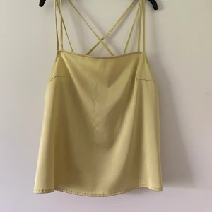 Topp/blus  - En fin sommar topp i silke som dessvärre har fått en liten blå fläck men de syns knappt och går säkert att få bort. I överigt är tröjan i fint skick. Fler bilder kan skickas vid intresse. Frakt ingår ej.