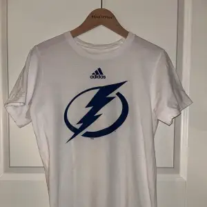 Kortärmad tröja från Adidas.  NHL Tampa Bay Lightning.  Mycket fint skick! Strl. S Pris 150 kr 