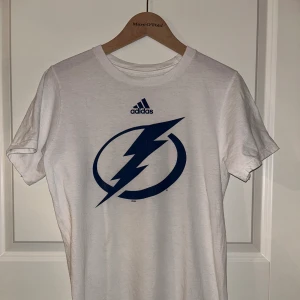 NHL Tampa Bay Lightning T-shirt  - Kortärmad tröja från Adidas.  NHL Tampa Bay Lightning.  Mycket fint skick! Strl. S Pris 150 kr 