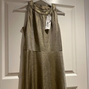 Klänning  - Skimrande/ glittrig klänning. Oanvänd med taggar kvar. Nypris 399kr