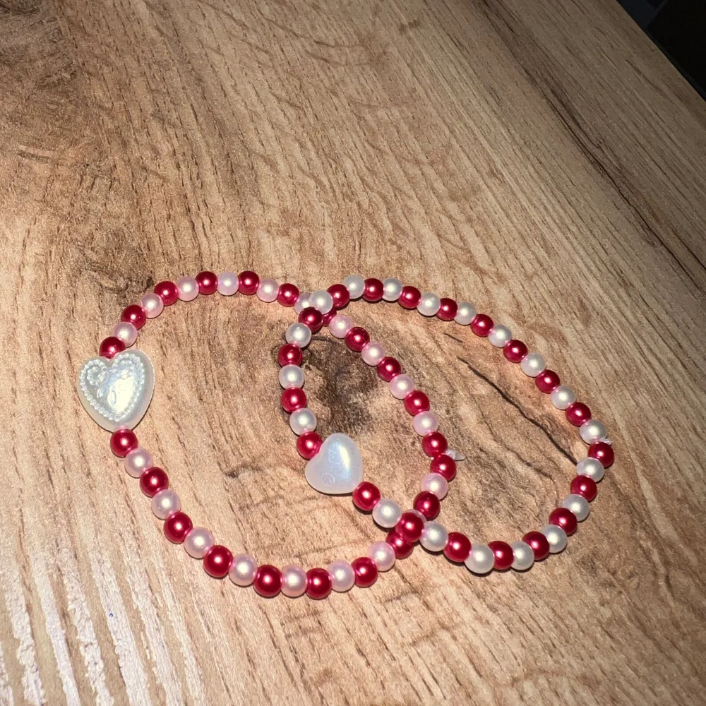 Armband i vita och röda pärlor + ett varsitt hjärta.. Accessoarer.