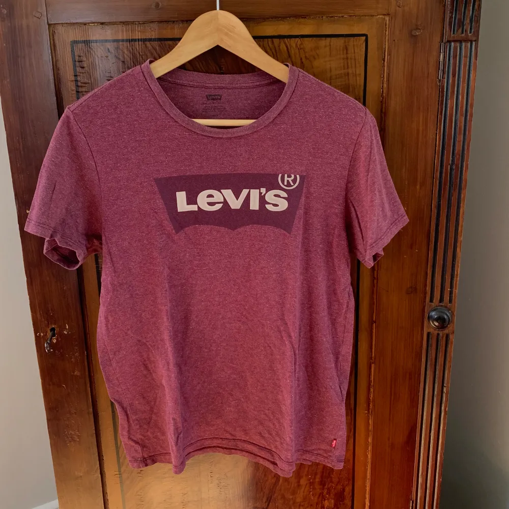 Vinröd melerad T-shirt med stor vinröd logga på bröstet. . T-shirts.