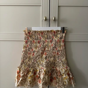 Blommig kjol - Blommig minikjol med smock från Zara. Knappt använd.