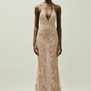 Maxi spetsklänning - Super fin lång spetsklänning med vackra detaljer i färgen beige/rosa. Tanken var att jag skulle ha den till balen men hittade en annan där av säljer jag den. Den är från hms studio kollektion 2023.