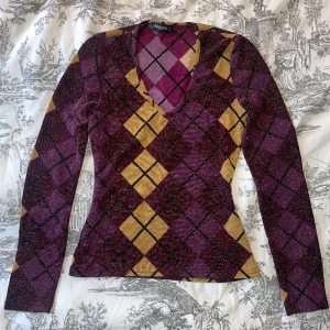 Topp med fin passform - Tröjan är i mönstrat, aningen glittrigt tyg.  Sitter superfint då den går in i midjan. Vill du ha flera bilder, skriv! 