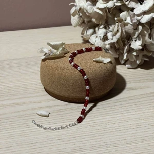 Armband - Izla - Detta armband passar extremt bra att lagra med något av våra andra armband eller bara ha för sig själv. Den har våra röda pärlor och vita som skapar ett fint mönster. Armbandet har en kedja i silver  Namn: Izla Längd: Hela 22,5 cm, Pärlor 15 cm