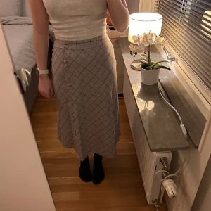 Lång kjol - Säljer en grå kjol som är blå/röd rutig. Köpt på mango. Storlek S. Endast använd ett fåtal gånger. Nyskick. Jag är 161 cm för referens. 