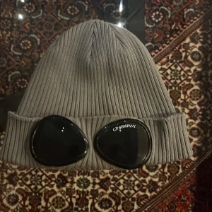 C.p. Company mössa  - Hej! Säljer min C.P. Company mössa. Den är vi väldigt bra skick. Bara lite smötdia glasögon men annars inget (9/10) äkta såklart! Är det något man kan undra över är det bara att fråga 🙋‍♂️ är ganska fast med priset. Men kan ändra vid snabb affär. //O