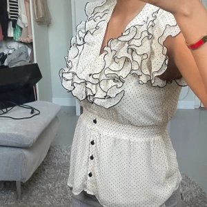 Topp med volanger  - Supersöt topp med volanger och knappar 