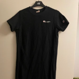 Champion klänning - Svart kortärmad klänning som kommer strax under knäna. Använd fåtal gånger, bra skick!