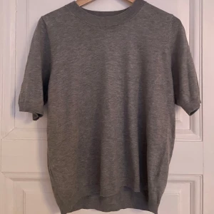 Stickad grå t-shirt  - Grå stickad t-shirt, använd cirka 2-3 gånger men är i mycket bra skick 
