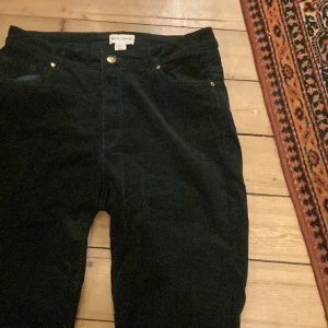 Mörk gröna manchester byxor - Straight leg och medium high waist. Mörk grön färg som nestan går mot svart i mörkt ljus. Manchestertyg i tunna, små randar. Nytrala men samtidigt ett statement!