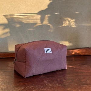 Brun handgjord necessär - Brun necessär med snea linjer och beige innertyg. Säljs vanligen för 550kr på min hemsida, men dragkedjan är aning knepig på ena sidan - annars felfri. Mått L 20 W 12 H 10