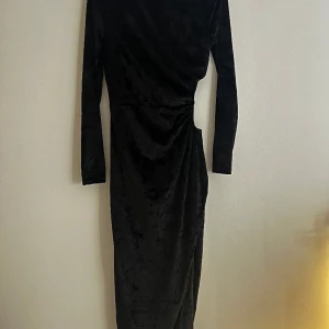 Klänning  - Sammetsklänning med öppen sida och slits. Strl 36. 