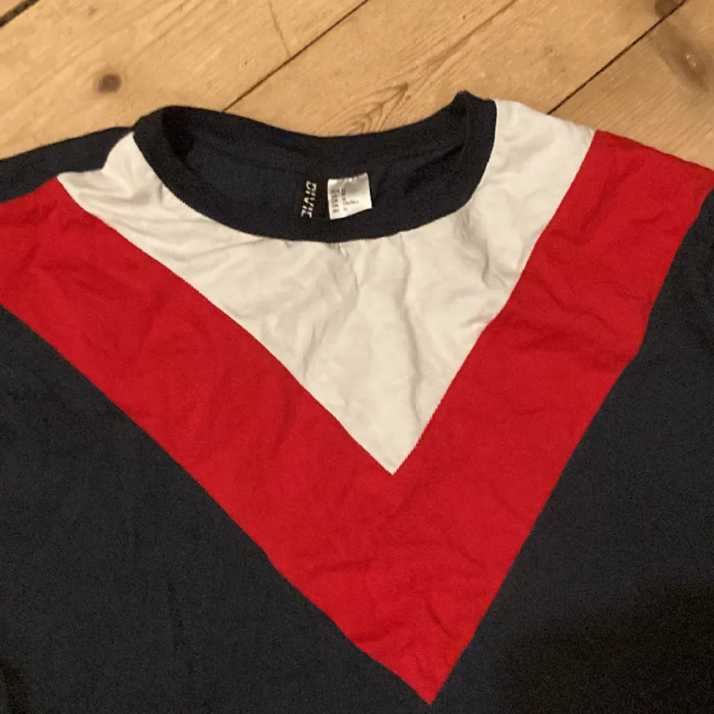Röd, vit och mörk blå magtröja som kan passa storleker 36-42. . T-shirts.