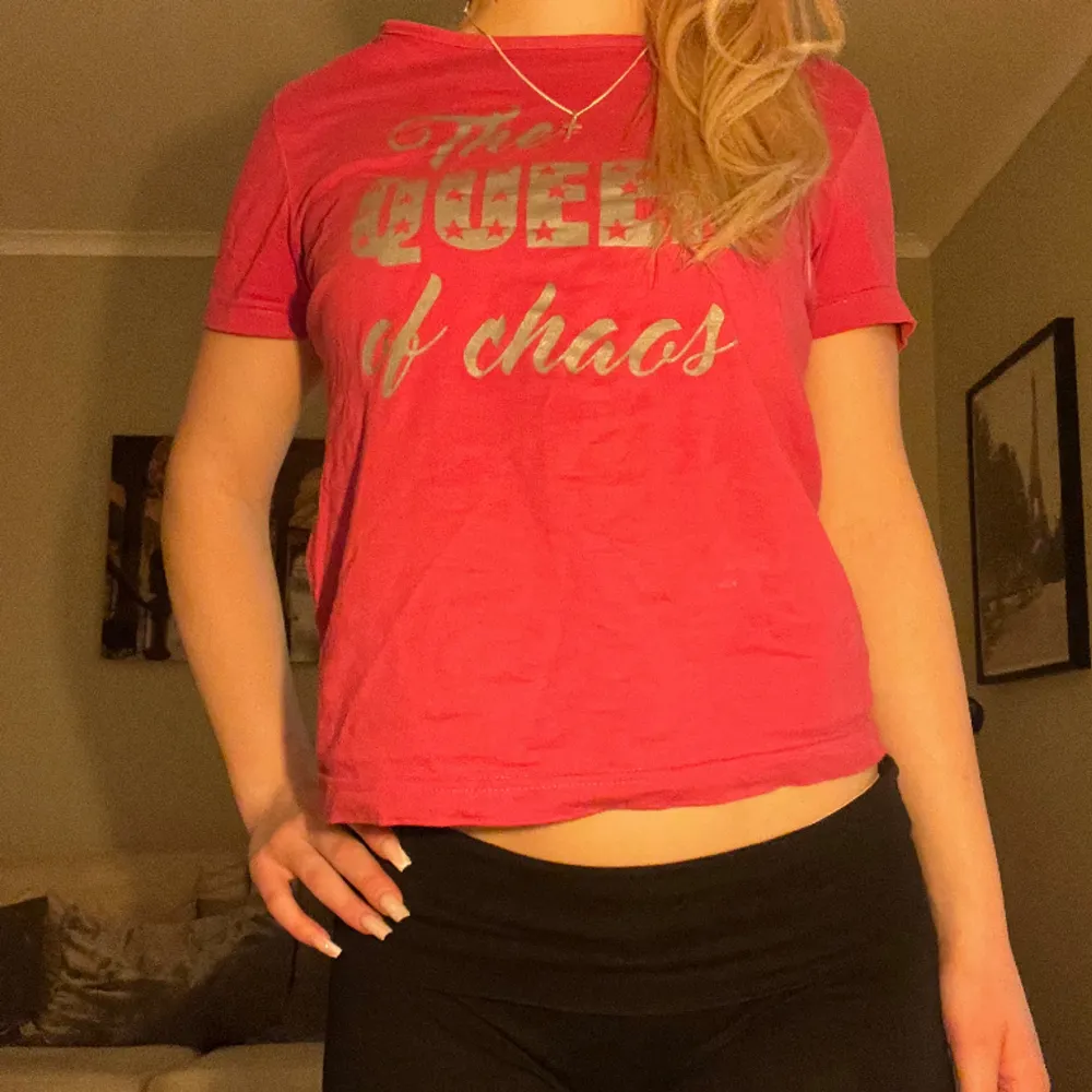 Säljer denna snygga, cola, rosa t-shirten som har silvrig text med ”The Queen of chaos” och kommer ej till användning💗den sitter ganska tajt och därför ger snygg form! Knappt använd.. T-shirts.
