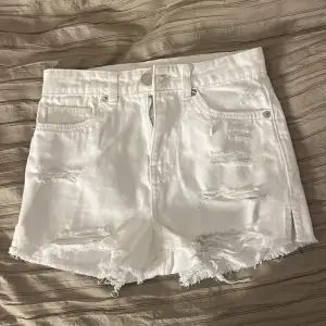 Säljer ett par vita shorts som är köpta trasiga som det ska vara i storleken XXS med hög midja. Använda ett par gånger.💞