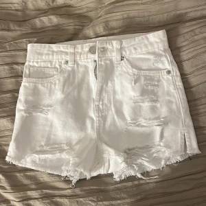 Vita shorts  - Säljer ett par vita shorts som är köpta trasiga som det ska vara i storleken XXS med hög midja. Använda ett par gånger.💞