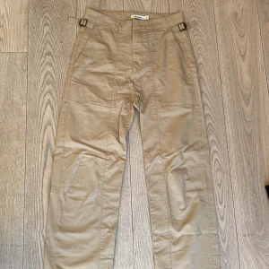 Carin Wester beige byxor stl 38 - Snygga beige byxor från Carin Wester. Spännen som kan dras åt i midjan. 