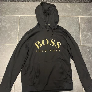 Hugo boss hoodie  - Säljer denna sjukt snygga Hugo boss hodddie i ANVÄNT skick. Den är i storlek M men passar även S. Säljer den billigt då den har ett hål i vänster arm. Det är bara att skriva om du har fler frågor och om du vill ha fler bilder på hoddien. 