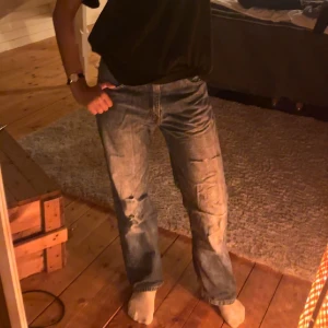 Blåa Levis jeans - Blåa vintage Levis jeans med slitna hål säljer pga kommer inte till användning 