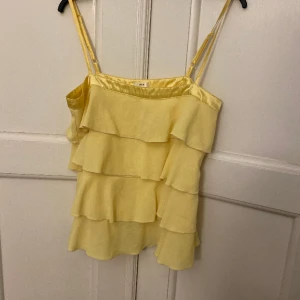 Gul volang topp - jättefin söt volang topp som jag säljer då den inte kommer till användning. Står ingen storlek men skulle säga storlek S. 