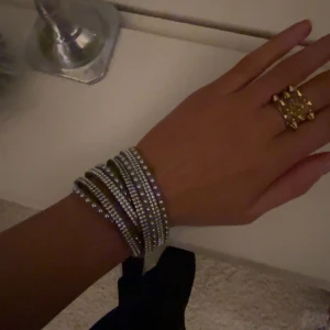 Armband  - Grått armband mer glitter på!  I fint skick och är justerbart med tre knappar man knäpper armbandet med🩶