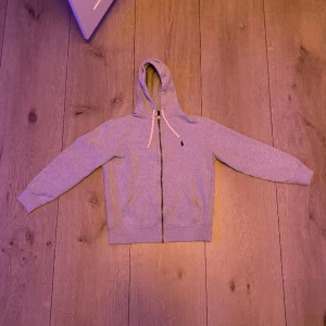Polo Ralph Lauren zip tröja  - Tja! Säljer min Polo Ralph Lauren Zip Hoodie eftersom den blivit ganska liten på mig nu. Inga fel på den använd några gånger men inga fläckar eller konstigheter Storlek M. Med frågor osv bara att skriva mvh, Kalle.