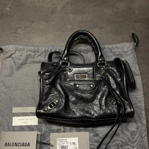 Balenciaga väska - Säljer nu min Balenciaga mini city väska då den ej kommer till användning.  Nypris cirka 13.000kr, använd ett fåtal gånger och ser helt ny ut.  Har kvar alla kvitton och allt material från när jag köpte den, dustbag medföljer samt det långa bandet.