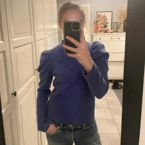 Blå topp - Klarblå tröja med puffaxlar. 