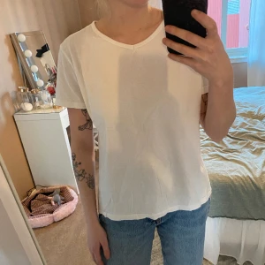 T-shirt  - Vanlig vit t-shirt med en lätt v-ringning.