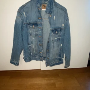 Jeansjacka  - Mörkblå oversize jeansjacka med slitningarna. Köpt på New Yorker, nytt pris 500 kr, jag säljer för 260 kr. 