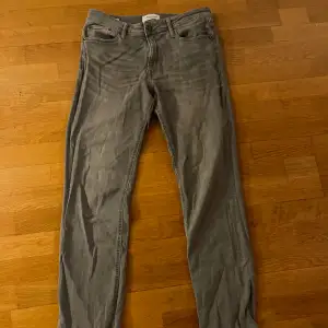 Gråa jeans från Jack&Jones i modellen ”Clark”. Regular fit och storlek 31/34. Har använts en del men i mycket fint skick! 188 lång för referens. Skriv vid eventuella frågor! :)