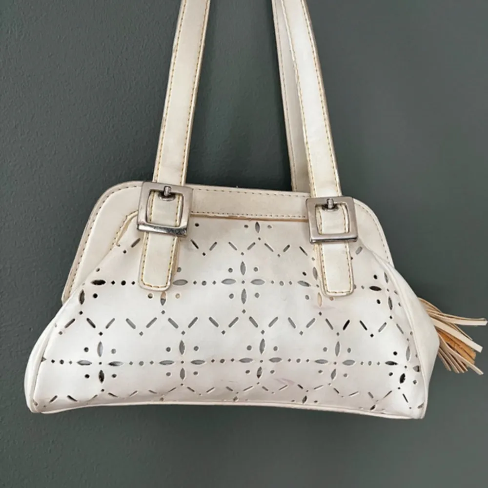 A vintage geometric style women hand bag in off white. Perfect size for daily use and lots of room for phone, keys, make up and wallet. There are some minor discolouration hence the low price. The bag exterior is faux leather. Väskor.