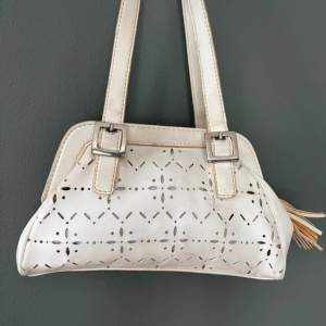 A vintage geometric style women hand bag in off white. Perfect size for daily use and lots of room for phone, keys, make up and wallet. There are some minor discolouration hence the low price. The bag exterior is faux leather