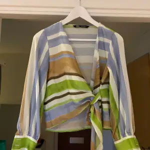 Storlek: XS En skjorta från Zara med detaljer som knappar längst ner vid ärmarna samt ett snöre som man knyter ihop skjortan med. Den är i ett fint skick då den är använd ett fåtal gånger.  Köparen står för frakten 