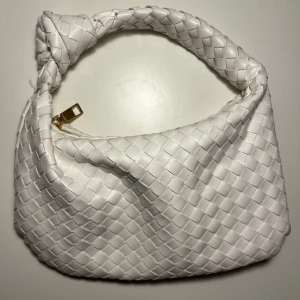 Vit flätad väska - Säljer min jättesöta Bottega Veneta-liknande flätade väska som är väldigt trendig just nu. Perfekt inför sommaren☀️. Den är liten men får absolut plats med det viktigaste (telefon, plånbok, läppglans etc)😍
