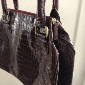 Krokodil mönstrad väska - Knappt använd väska köpt på secondhand för många år sen. Jättefint skick! Dragkedjan funkar perfekt. Inuti mycket plats med en stor ficka med dragkedja och en liten öppen ficka. Av märket Oriflame Sweden