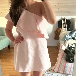 Ljusrosa klänning - Ljusrosa one-shoulder klänning i storlek 34. Sytt upp den själv och för preferens är jag drygt 160 cm. Mycket fint skick!💗