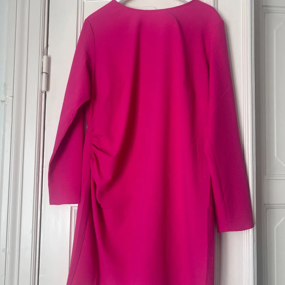 Rosa klänning från H&M med en liten knytdetalj på sida, storlek XL. Klänningen är aldrig använd och prislappen sitter kvar.. Klänningar.