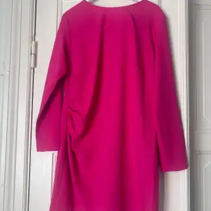 Rosa klänning från H&M med en liten knytdetalj på sida, storlek XL. Klänningen är aldrig använd och prislappen sitter kvar.